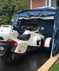 customer image of a deluxe speedway shelter with floor in a backyard open with a white 2017 CAN-AM® SPYDER® RT 6-SPEED SEMI-AUTOMATIC inside with extra room