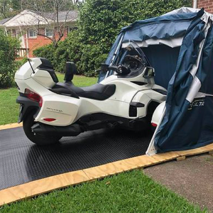 customer image of a deluxe speedway shelter with floor in a backyard open with a 2017 CAN-AM® SPYDER® RT 6-SPEED SEMI-AUTOMATIC inside with extra room