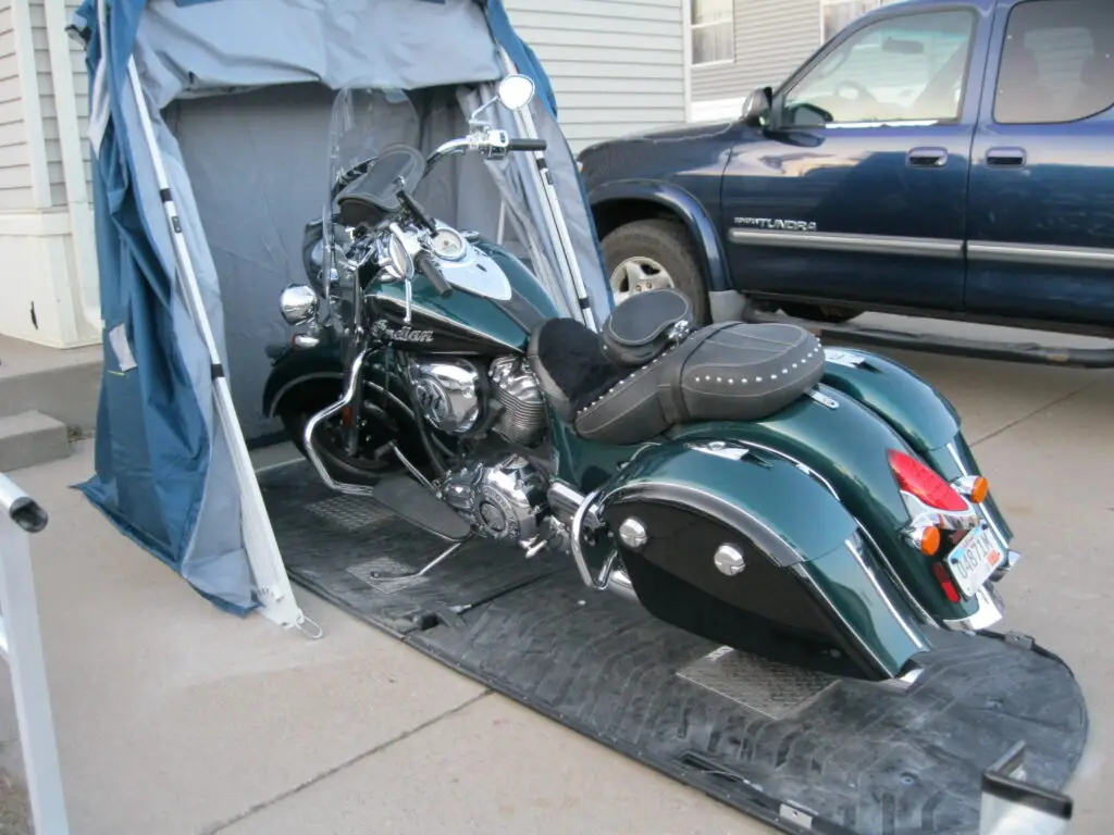 Green Harley-Davidson touring motorcycle parked beside a Speedway Shelter