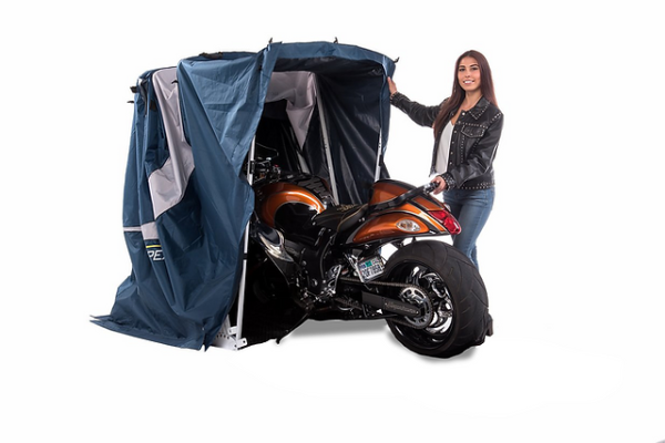 biker easily putting away her sport motorcycle in the sport speedway shelter