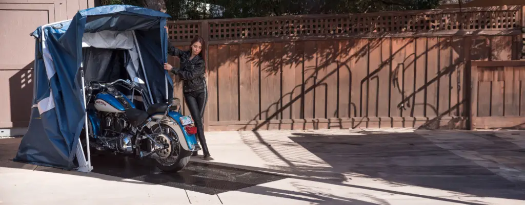 Closing the Touring Speedway motorcycle shelter over a blue Harley-Davidson
