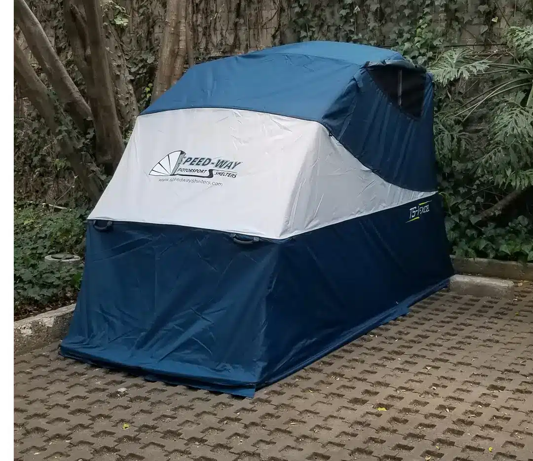 Touring Speedway motorcycle storage shelter closed outdoors, shading a motorcycle from the sun