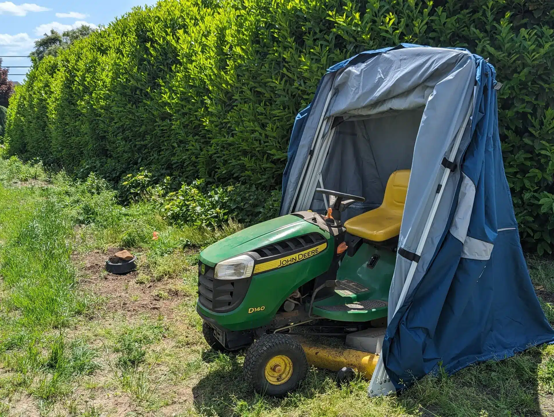 Riding lawn mower stored in a Speedway Shelter on the grass