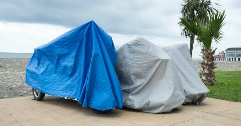 motorcycles stored under tarps