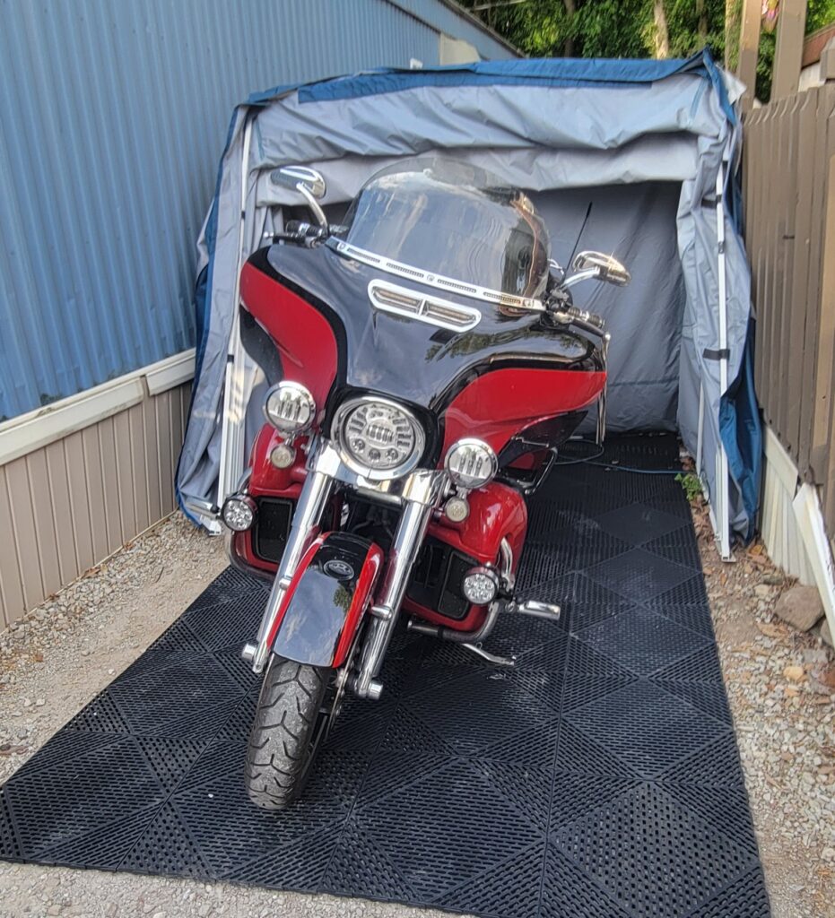 Red Harley-Davidson touring bike on rubber flooring inside a Speedway Shelter