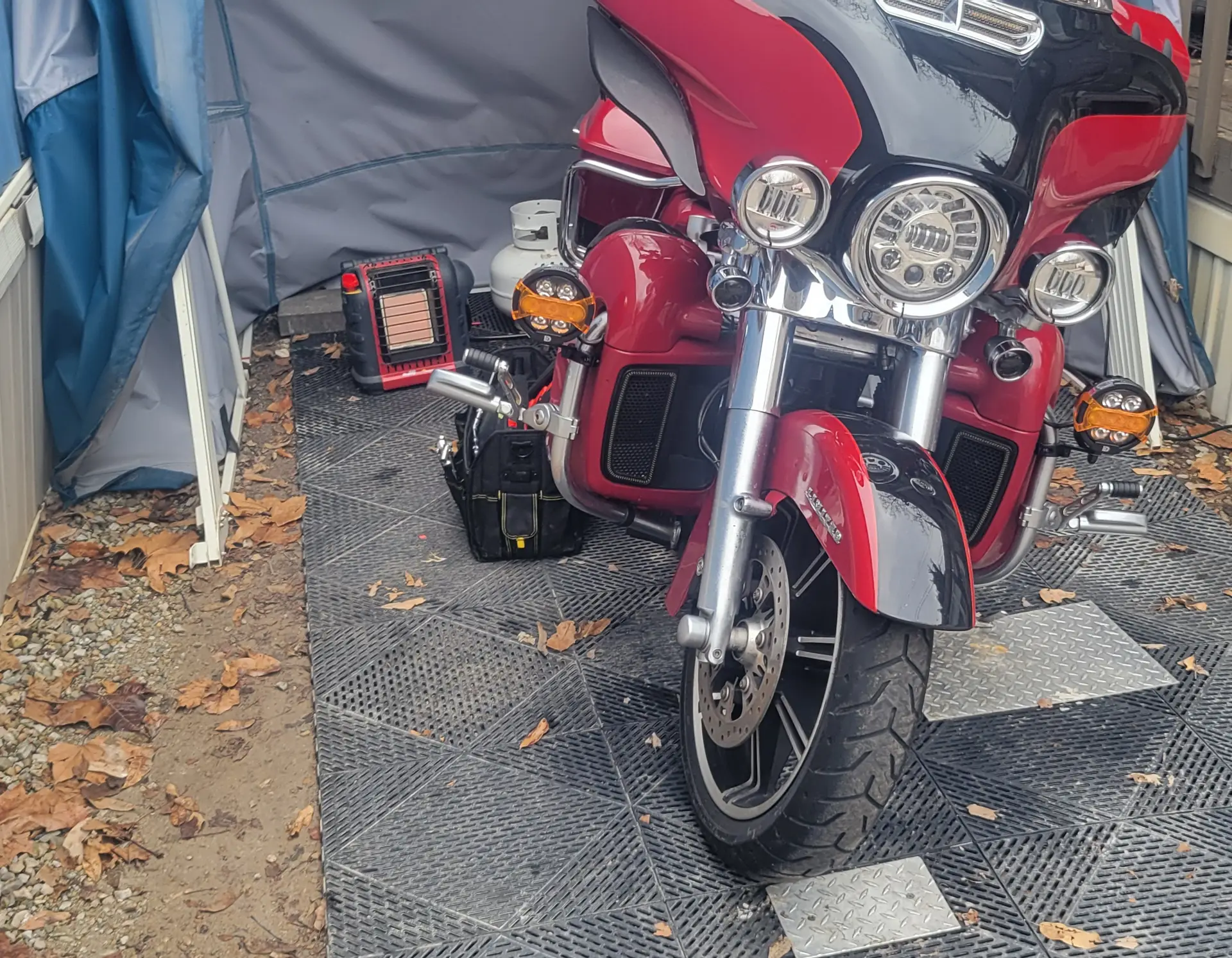 Red Harley-Davidson touring bike inside a Speedway Shelter used as a winter workshop
