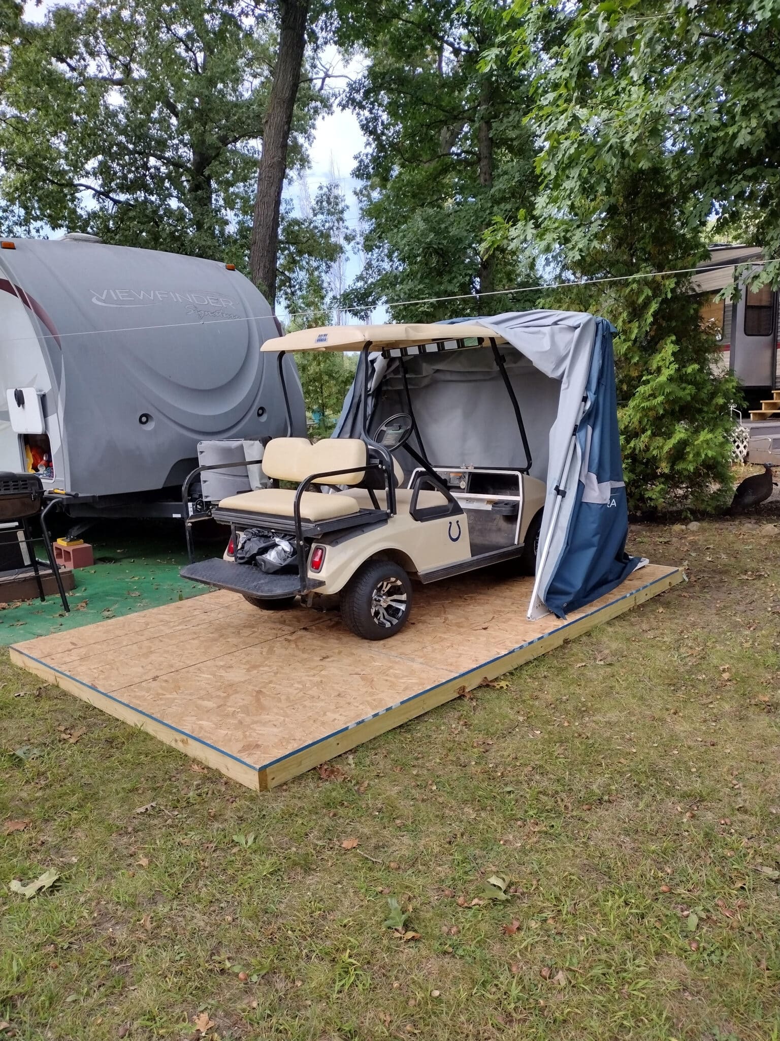 Golf cart parked in a Deluxe Speedway Shelter on a wooden deck