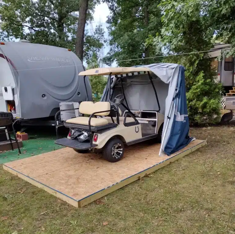 Golf cart parked in a Deluxe Speedway Shelter on a wooden deck