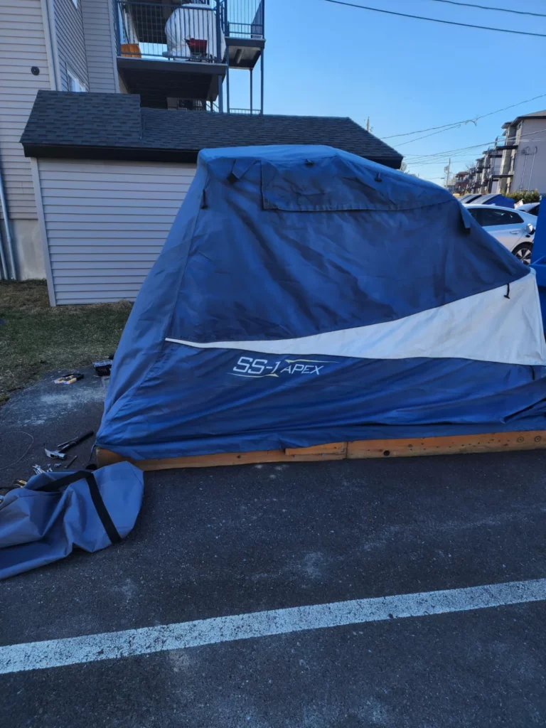 Speedway Shelter on a wooden base in a parking space