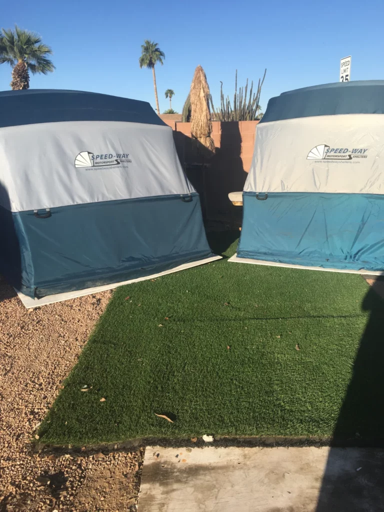 Two Speedway Shelters side by side on artificial turf in a desert backyard