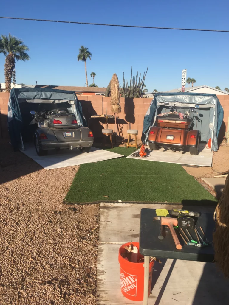 Two open Speedway Shelters in a desert backyard storing vehicles and gear