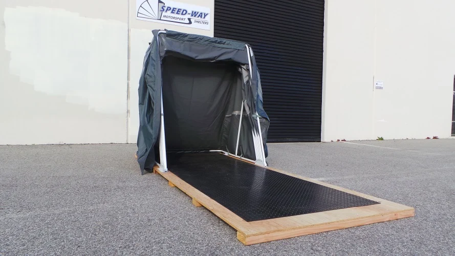 Speedway Shelter open on a plywood wood base, ready for a motorcycle