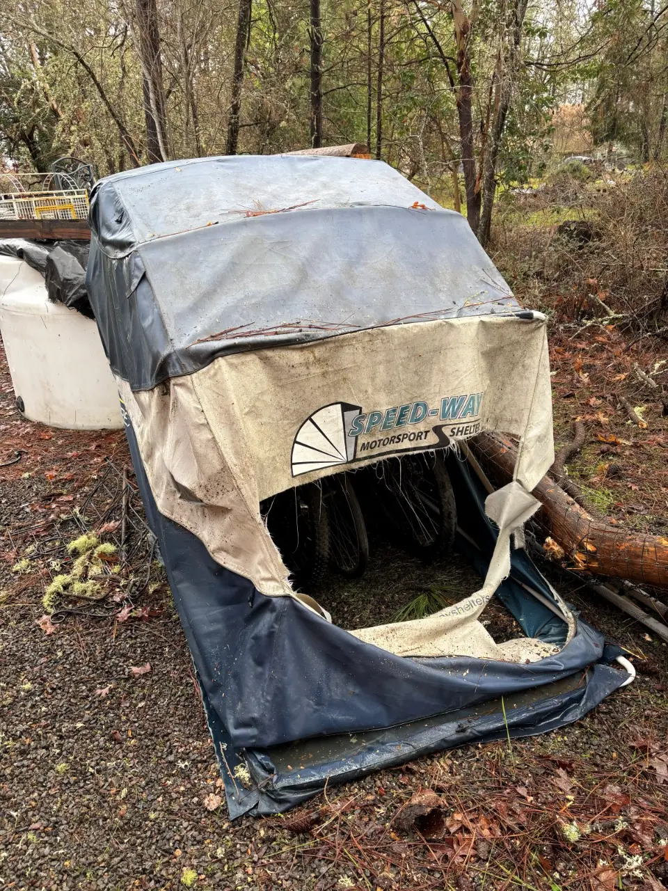 Speedway Shelter with a torn cover after a tree fell on it in a storm